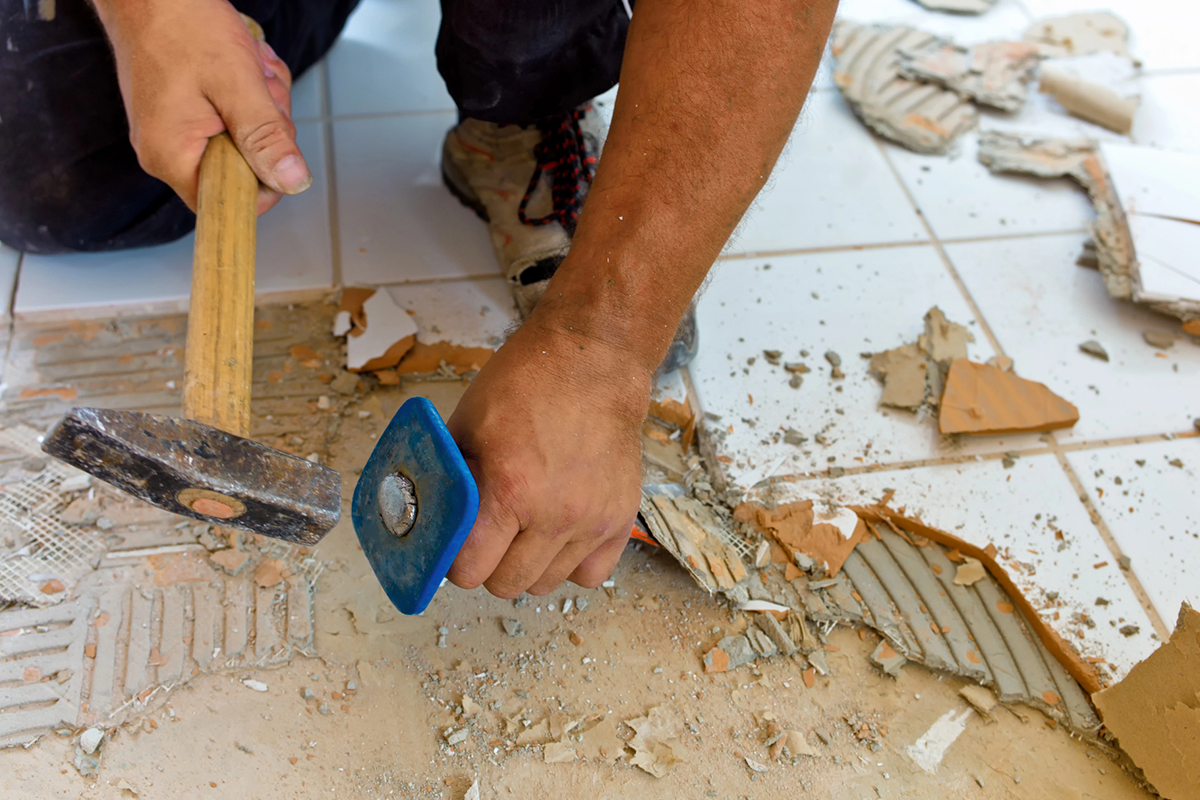 worker chipping up tile during Design Build Remodeling In Scottsdale, Paradise Valley, Surprise, AZ, Peoria, AZ, Glendale, AZ, and the Surrounding Areas